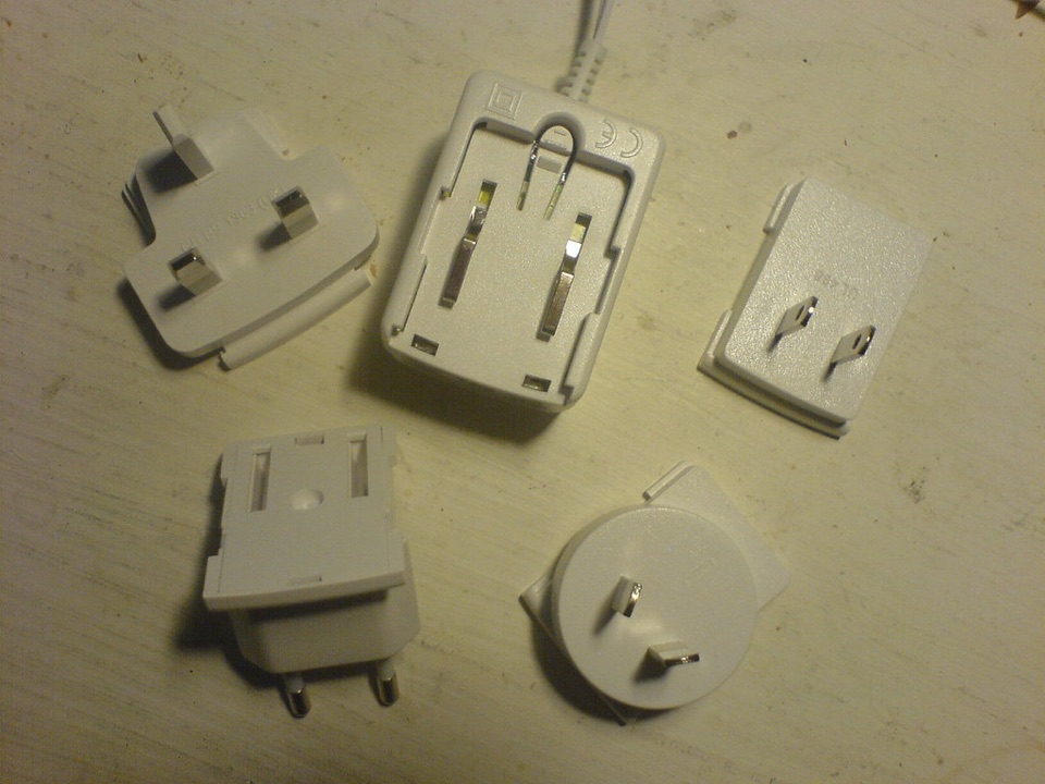 Five interchangeable plug heads for a travel adaptor on a table